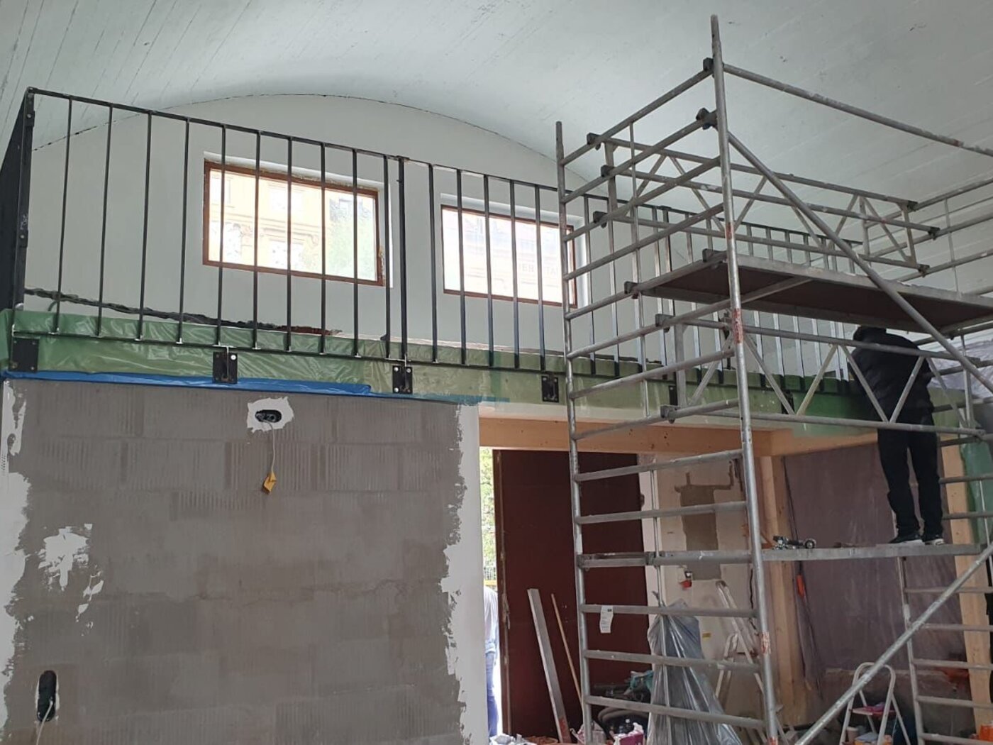 Fahrgerüst in einem Gewölberaum, dahinter eine neu aufgemauerte Wand und eine Galerie