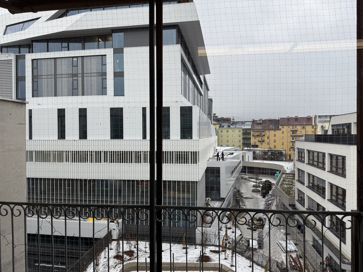 Neubau mit Gerüst und Schutznetz, vom Nachbargebäude aus gesehen