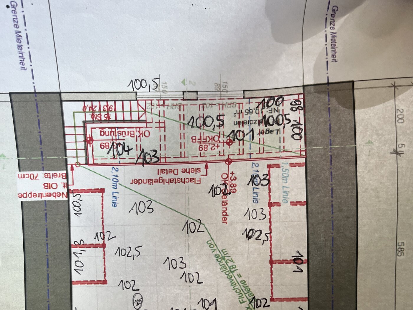 Ausschnitt eines Bauplans mit roten Eintragungen und handschriftlichen Maßen