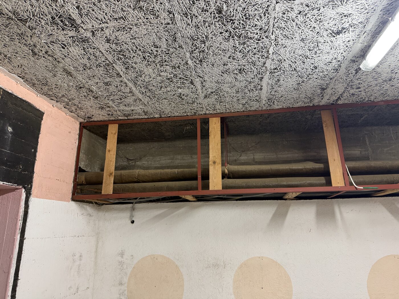 Geöffnete abgehängte Decke, darüber die alte Holzbalkenlage